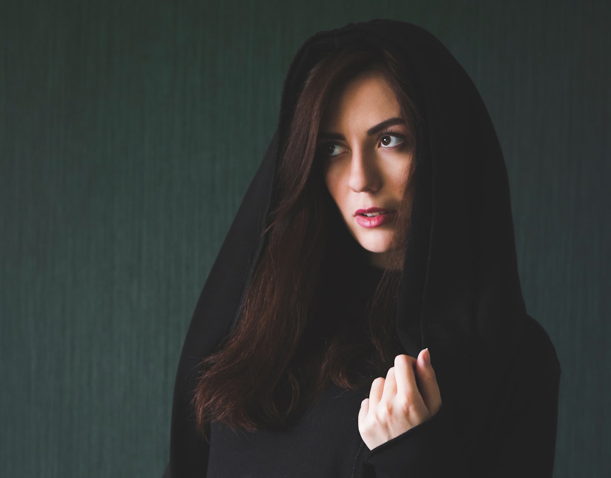 a young woman in a robe with a hood on her head looks to the left on a dark green background.
say "Thanks" via PayPal :) related to The Mysterious Allure of the Bed of Nails: Uncovering its Secrets