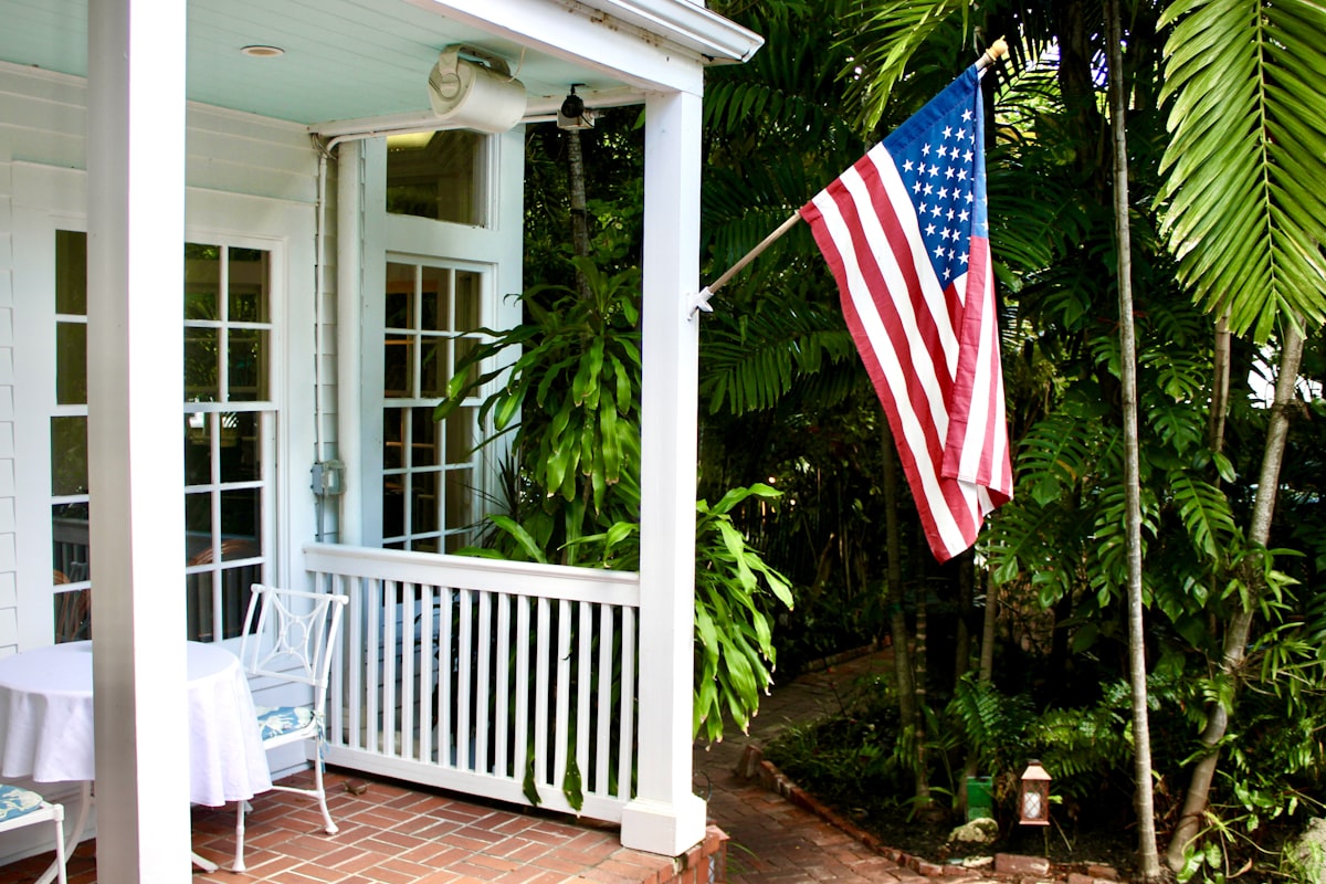 American flag on a porch with lush greenery related to Charming Stays in Paradise: Key West Bed and Breakfast