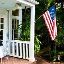 American flag on a porch with lush greenery related to Charming Stays in Paradise: Key West Bed and Breakfast