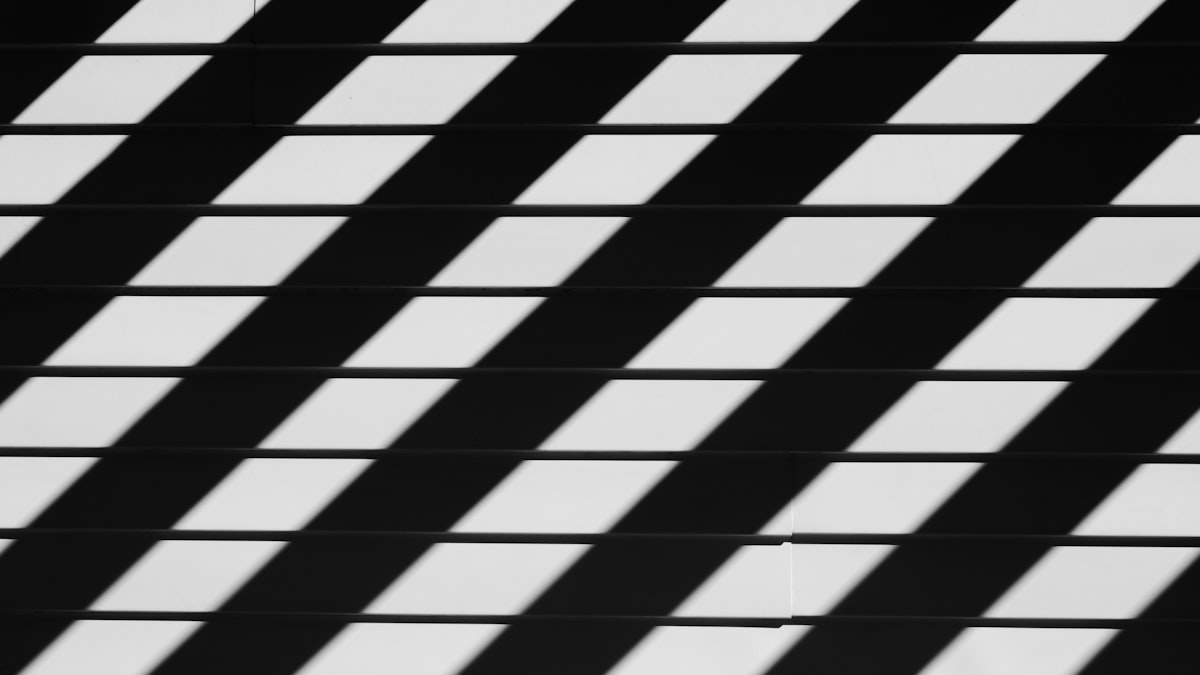 An abstract black-and-white photograph emphasizing geometric patterns of shadows and lines, evoking a sense of rhythm and structure. related to Elegant Black and White Stripe Valance: A Guide to Bedroom Decor