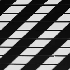 An abstract black-and-white photograph emphasizing geometric patterns of shadows and lines, evoking a sense of rhythm and structure. related to Elegant Black and White Stripe Valance: A Guide to Bedroom Decor
