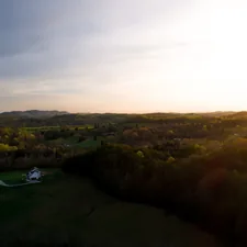 an aerial view of a field with a house in the distance related to Explore Cozy Stays in Knoxville, TN