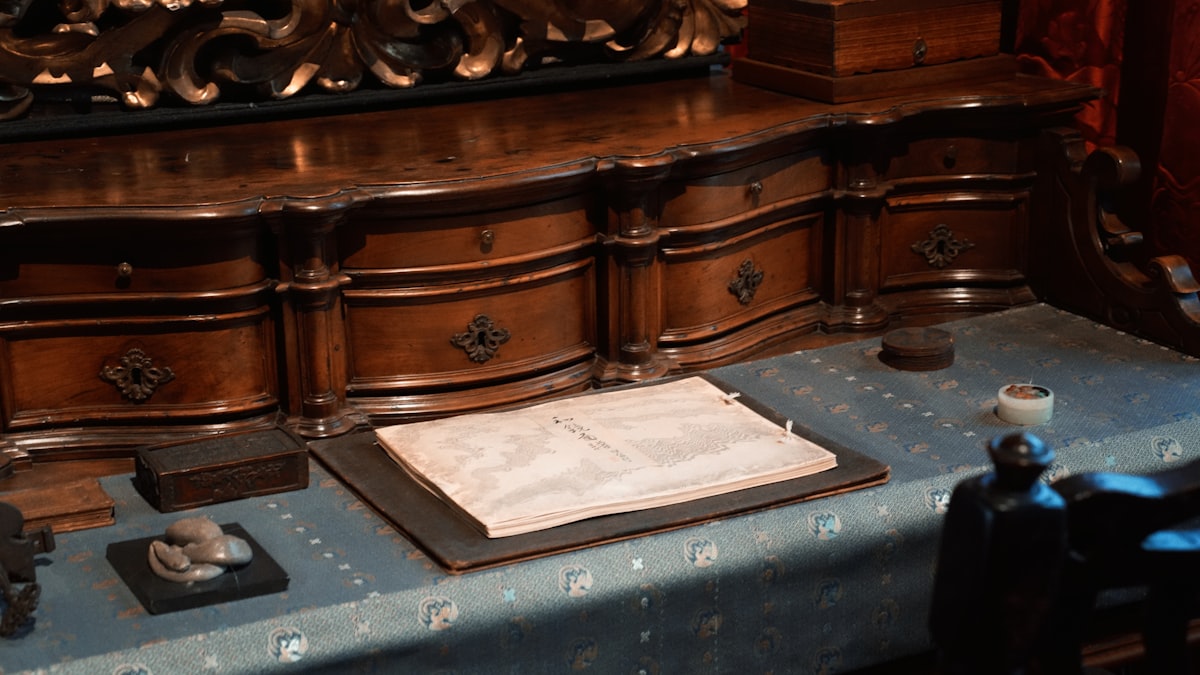 An antique desk with papers and writing tools related to Victorian Sideboard Buffet: A Timeless Statement Piece