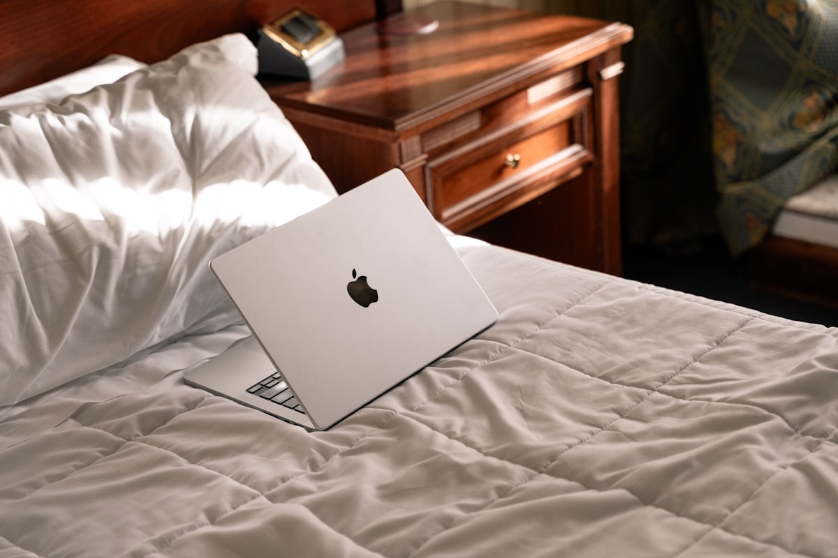 An apple laptop sitting on top of a bed related to The Ultimate Bed Bug Protector: Say Goodbye to Unwanted Guests