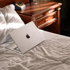 An apple laptop sitting on top of a bed related to The Ultimate Bed Bug Protector: Say Goodbye to Unwanted Guests