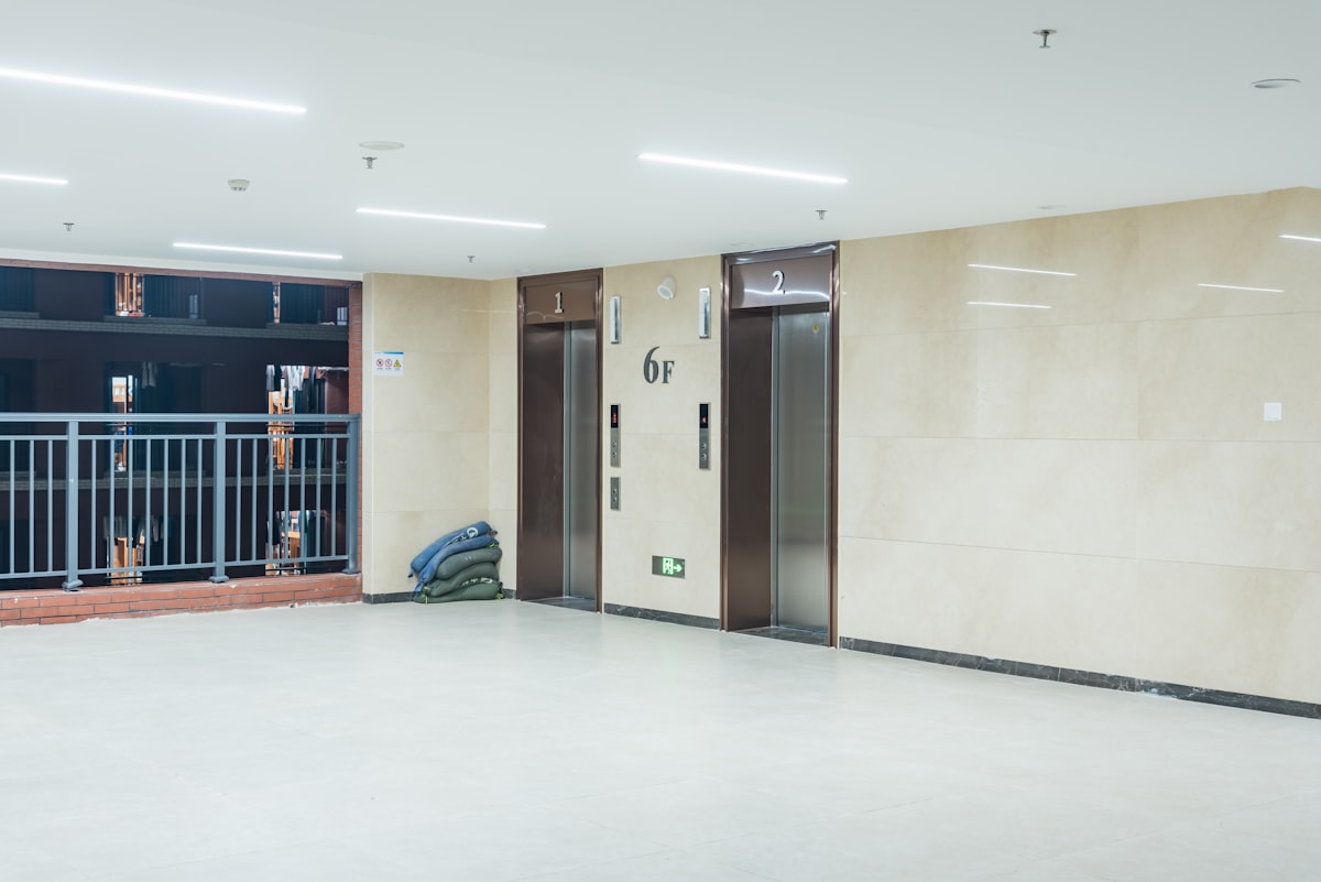 an empty room with two doors and a backpack on the floor related to Elevate Your Space: The Ultimate Guide to Lift Bed Frames