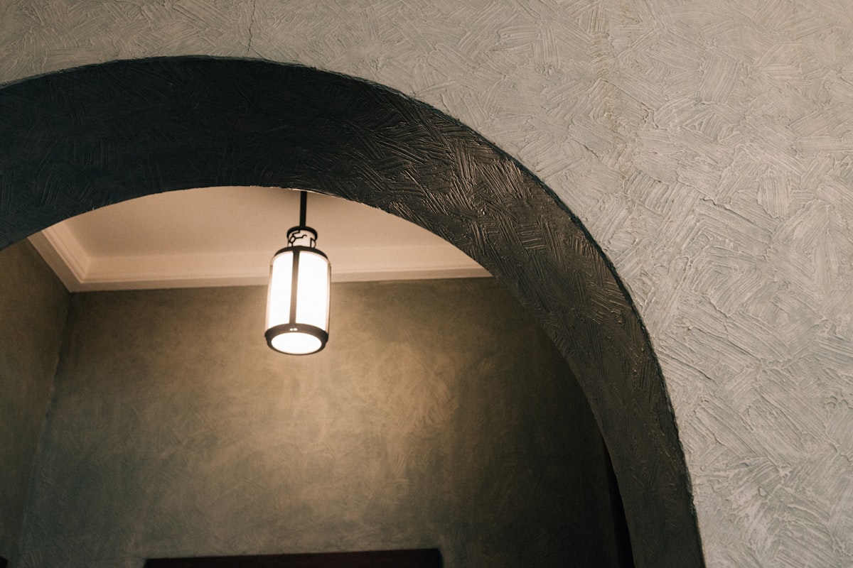 An illuminated lantern hangs under an archway. related to Illuminating the First Impression: Entryway Light Fixture Ideas