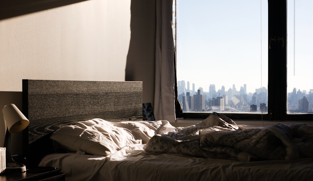 an unmade bed with a view of the city related to Effective Solutions for Bed Bug Infestation in New York City