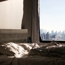 an unmade bed with a view of the city related to Effective Solutions for Bed Bug Infestation in New York City