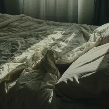 an unmade bed with a window in the background related to Uncovering the Reality of Bed Bug Bites: A Visual Guide