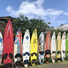 assorted-color surfboard standing under white and blue sky related to Second to None: Expertly Curated Second Hand Sideboards for Sale