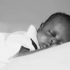 baby in white shirt lying on bed related to Creating a Timeless Nursery: Essentials for Black and White Baby Bedding