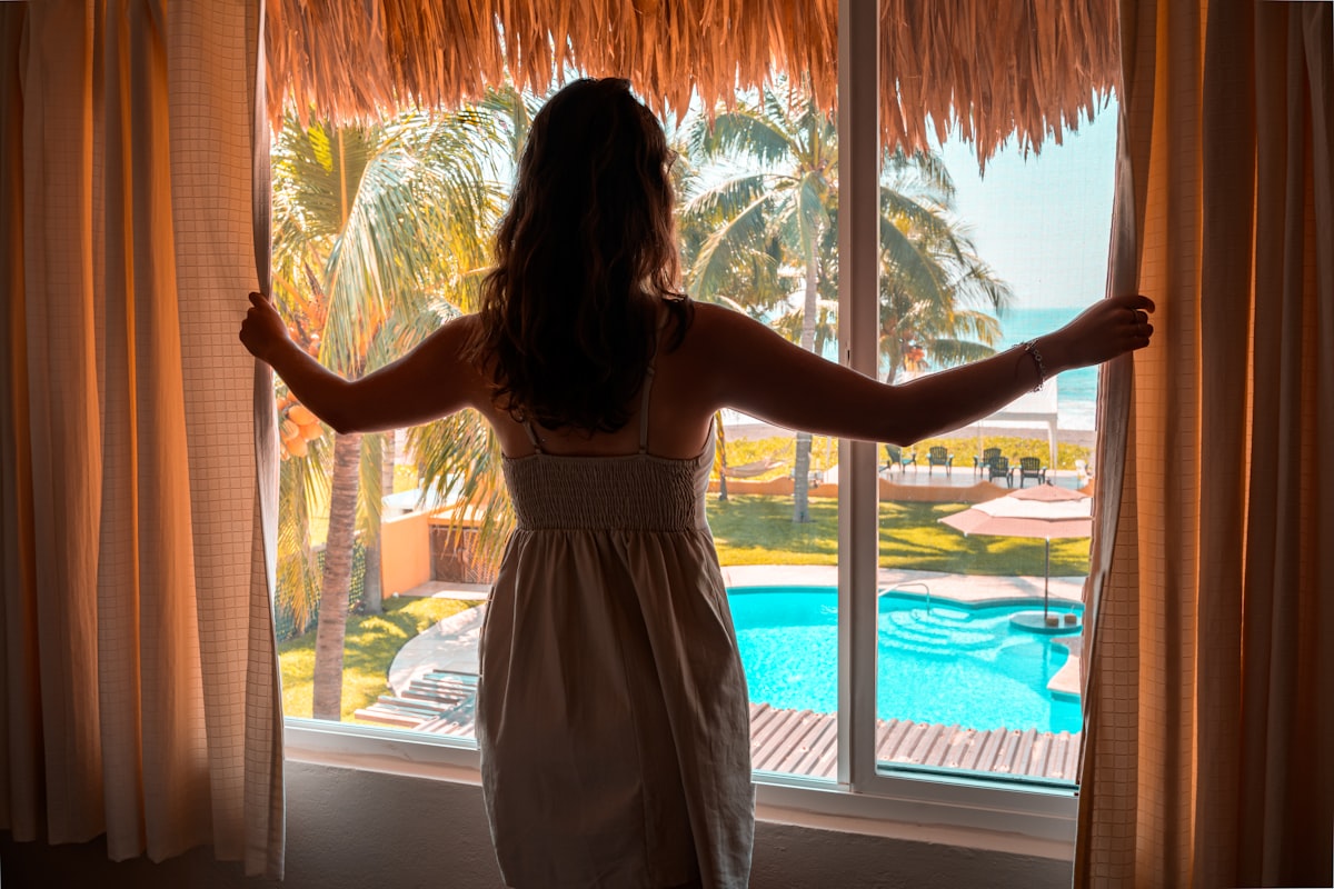 Beautiful woman waking up to the view of the ocean.  related to Beach-inspired Window Treatments
