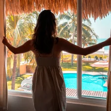 Beautiful woman waking up to the view of the ocean.  related to Beach-inspired Window Treatments