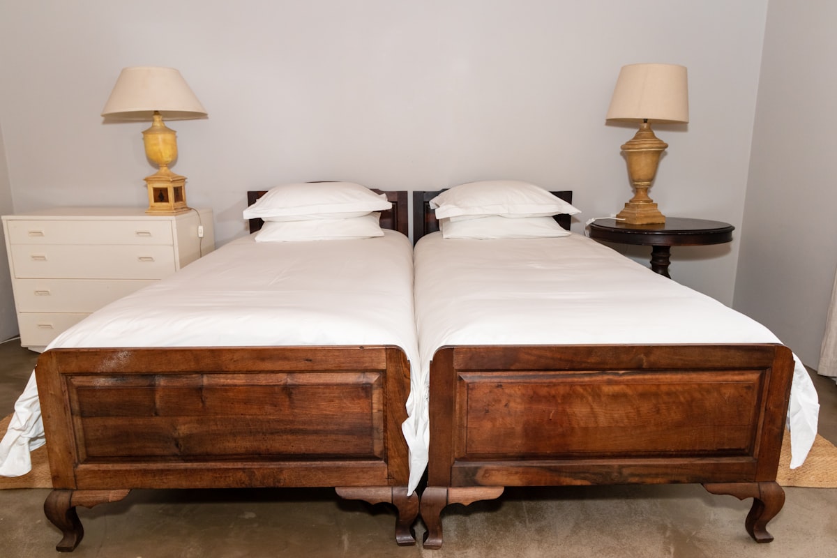 Bedroom in a farm cottage with a bedside lamps on bedside tables related to Elegant White Coverlets for Twin Beds
