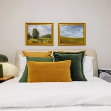 Bedroom with landscape paintings and green lamp. related to The Evolution of Modern Bed Frames