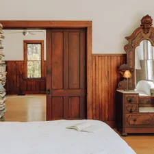 Bedroom with warm wood 1/3 (IG: @clay.banks) related to La Reserve Bed & Breakfast: A Haven of Comfort and Elegance