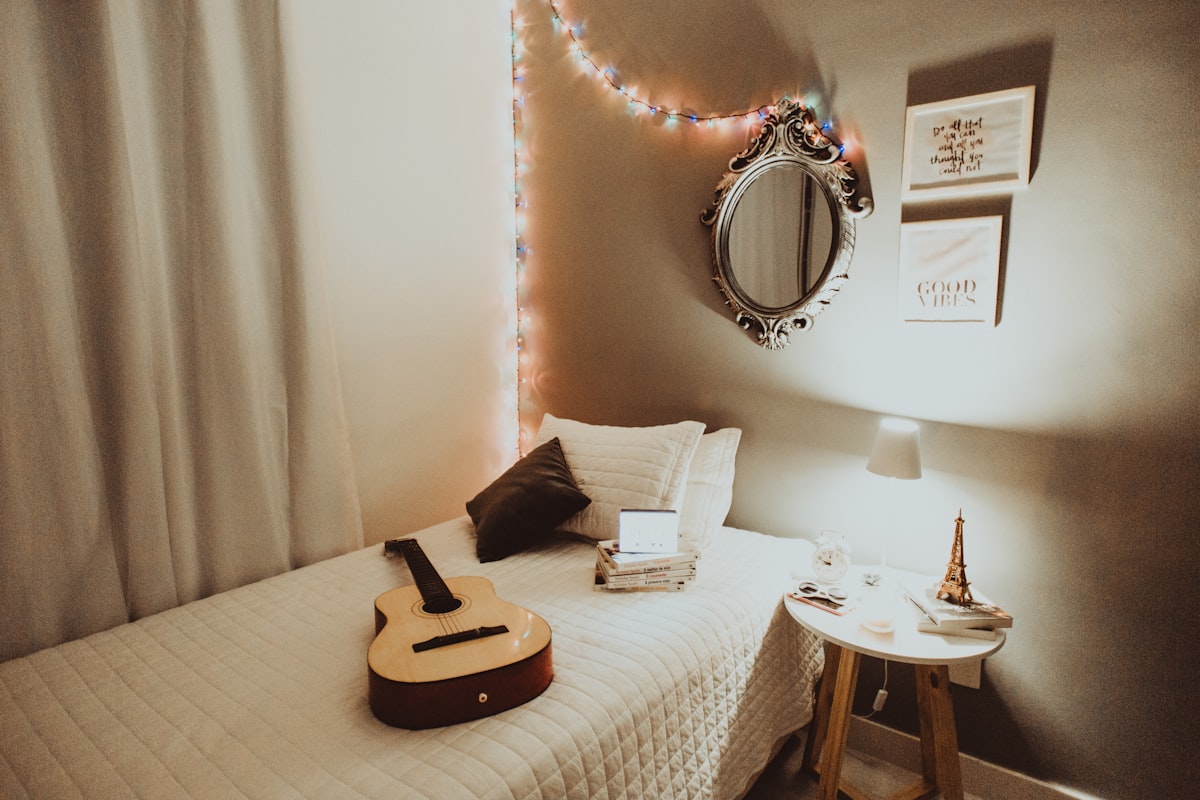 beige guitar on white bedspread related to Transform Your Bedroom with Music-Themed Bedding: Top Ideas for Music Lovers
