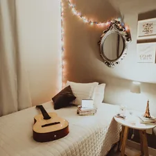 beige guitar on white bedspread related to Transform Your Bedroom with Music-Themed Bedding: Top Ideas for Music Lovers