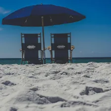 black and brown umbrella on white sand beach during daytime related to Discover the Charm of Destin Bed and Breakfasts