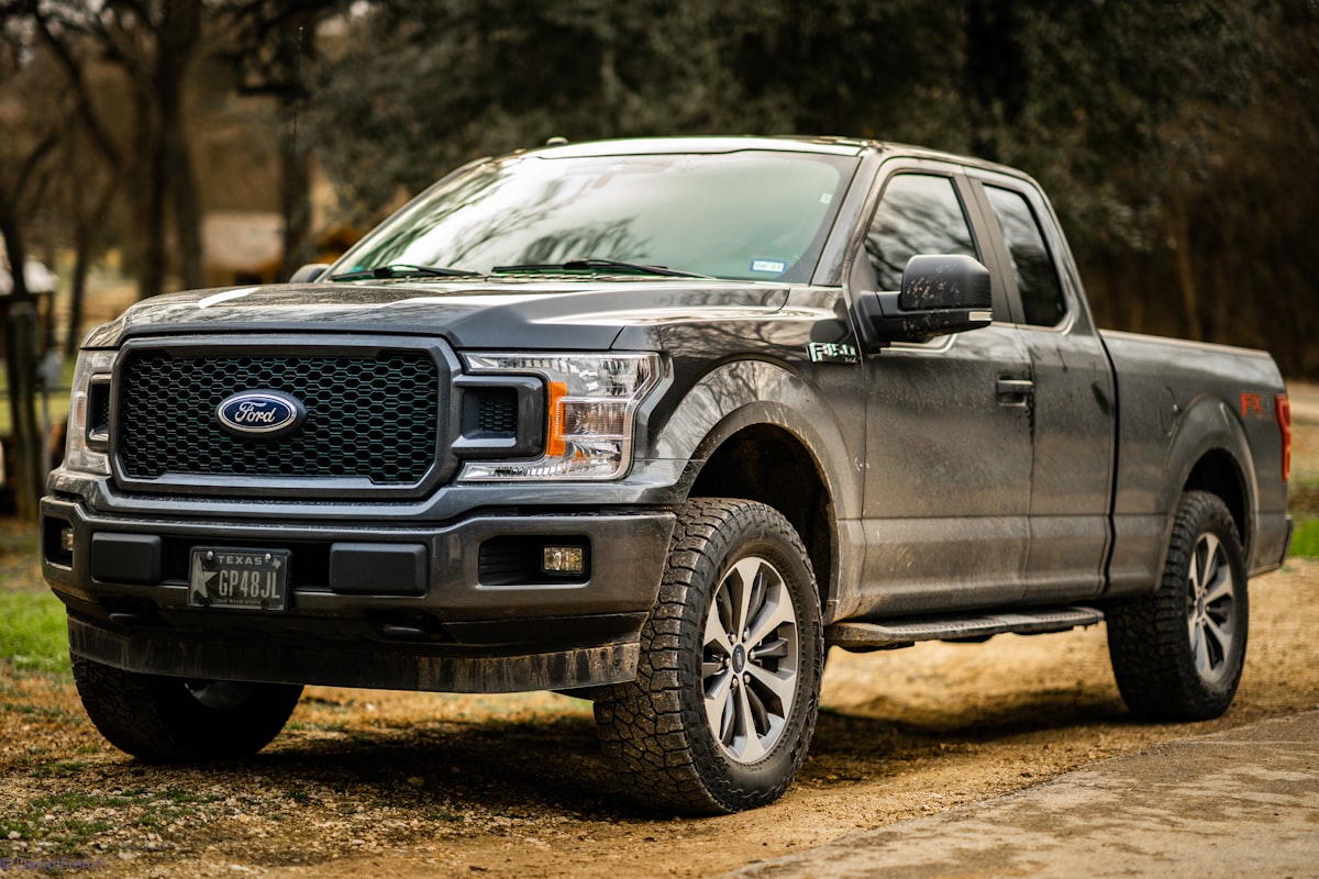 black ford suv on dirt road during daytime related to Optimize Your Ford F-150 Bed for Every Task