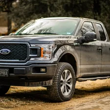 black ford suv on dirt road during daytime related to Optimize Your Ford F-150 Bed for Every Task