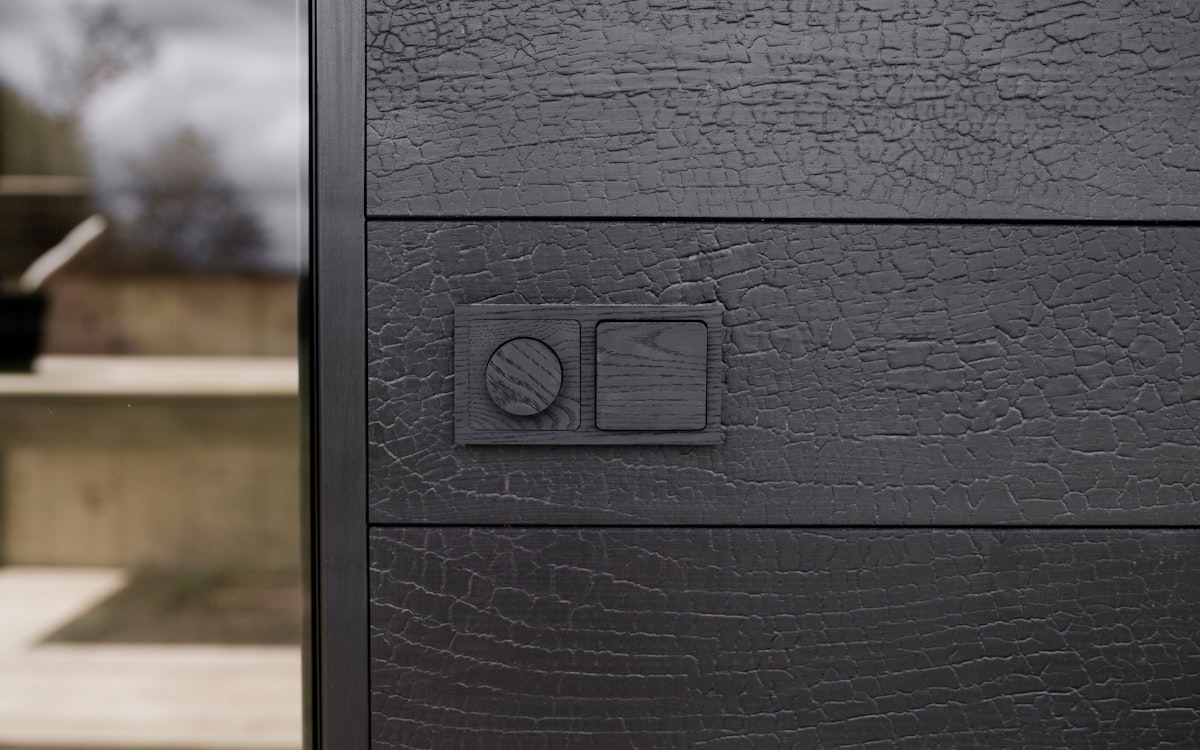 Black thermowood switches integrated into a textured wall, combining material depth with functional design. related to Dark Sideboard Furniture: Adding Depth and Drama to Your Home