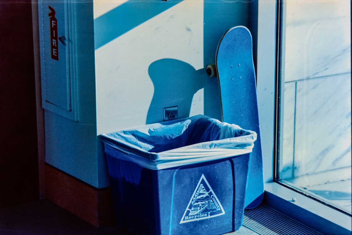 Blue trash can and skateboard by a window related to Choosing the Right Trash Cans for Your Home