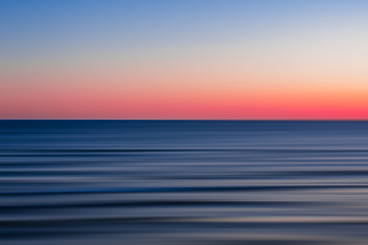 body of water during sunset related to Coastal Calm:  A Coral and Navy Bedroom Oasis