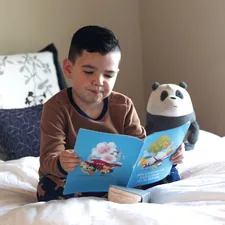 boy reading in his bed related to The Ultimate Guide to Bed Reading Pillows