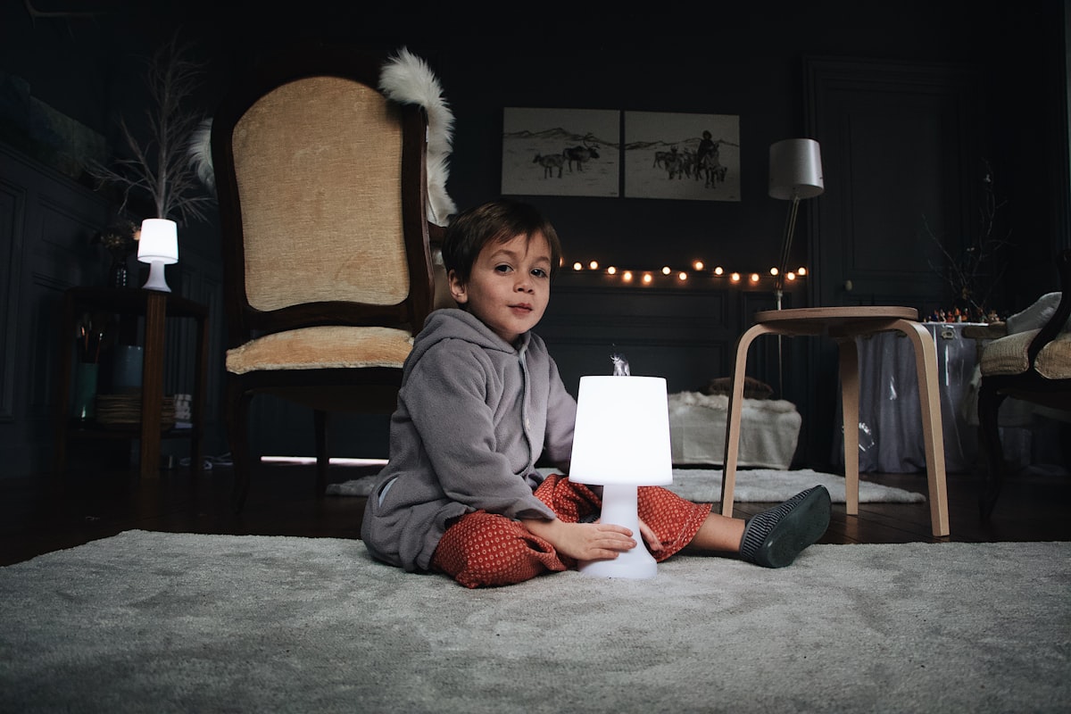 boy sitting in the floor holding a lamp related to Elevate Your Child's Room with Kids Window Valances