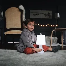 boy sitting in the floor holding a lamp related to Elevate Your Child's Room with Kids Window Valances