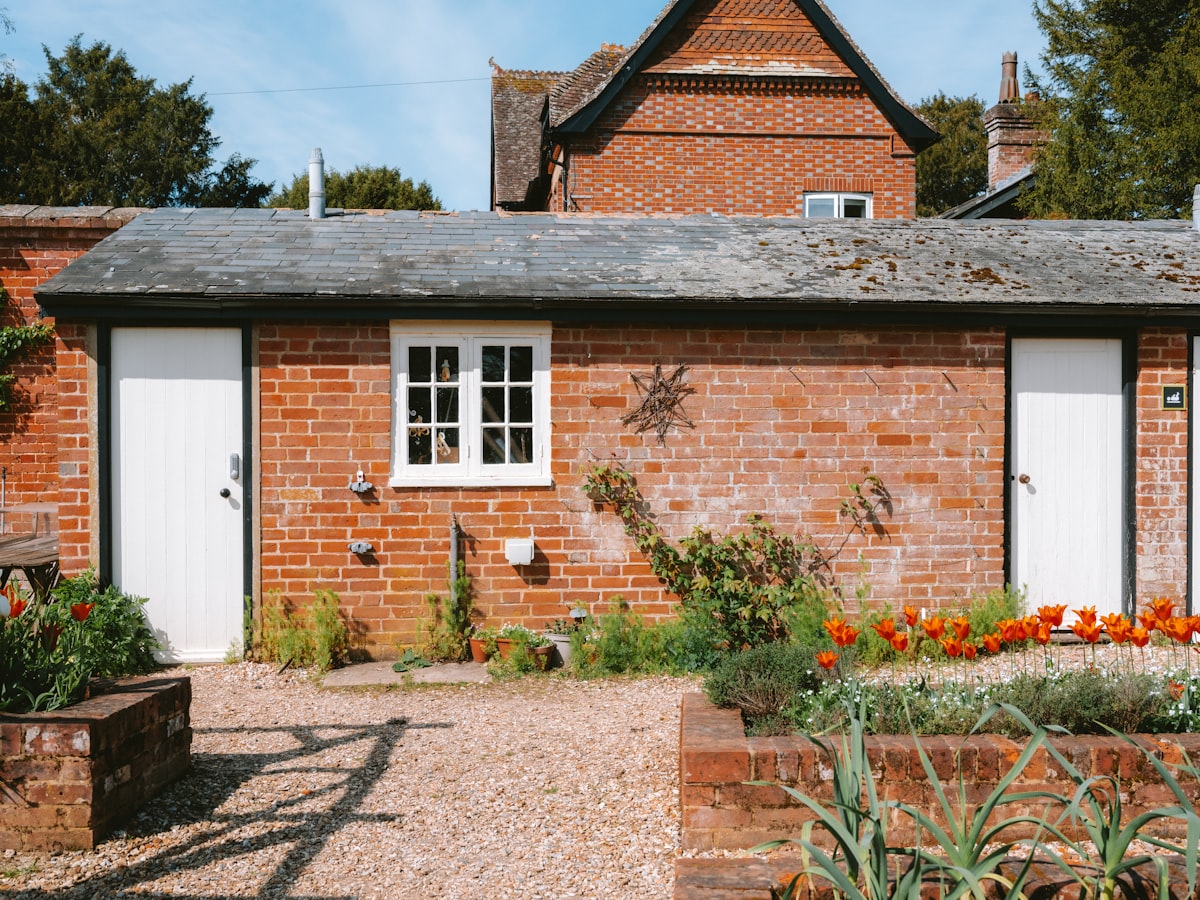 Brick building with white doors and a small window. related to Dreamy Retreats: The Ultimate Guide to White Day Beds