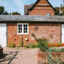 Brick building with white doors and a small window. related to Dreamy Retreats: The Ultimate Guide to White Day Beds