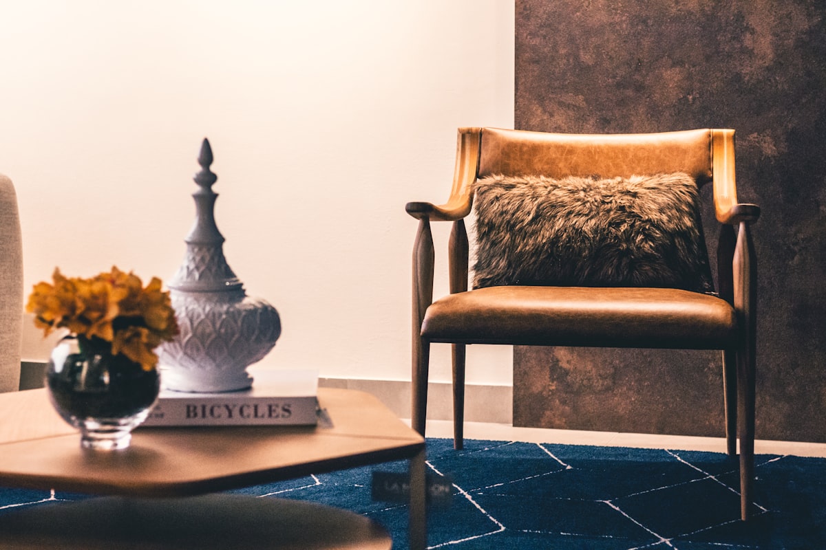 brown and black armchair beside white ceramic vase related to Elevate Your Decor: The Luxe Appeal of Gold Valance Curtains