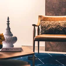 brown and black armchair beside white ceramic vase related to Elevate Your Decor: The Luxe Appeal of Gold Valance Curtains