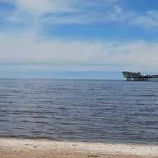 brown wooden dock on sea under blue sky during daytime related to Charming Bed and Breakfast Escapes in Southport, NC