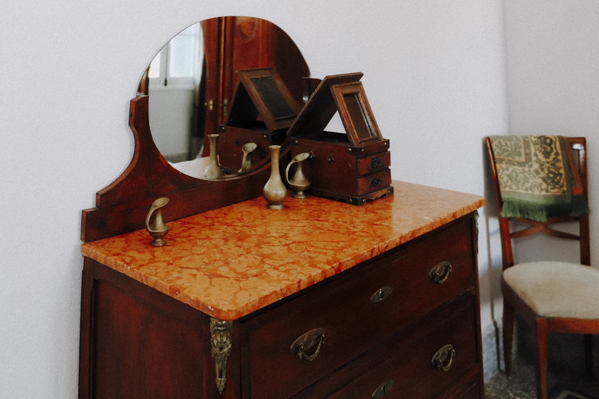 brown wooden framed mirror on brown wooden drawer related to Elegant Additions to Your Home: Antique Sideboards with Marble Tops