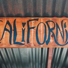 brown wooden welcome to the beach signage related to Slumbering in Style: A Guide to California King Bed Sheets