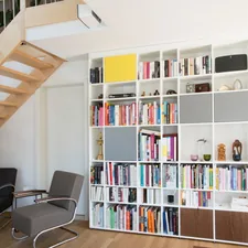 Ceiling-high shelf in a material combination of MDF and solid wood. Used as a bookshelf in a living room. related to Transforming Spaces: The Ultimate Guide to Amazon Kids Beds
