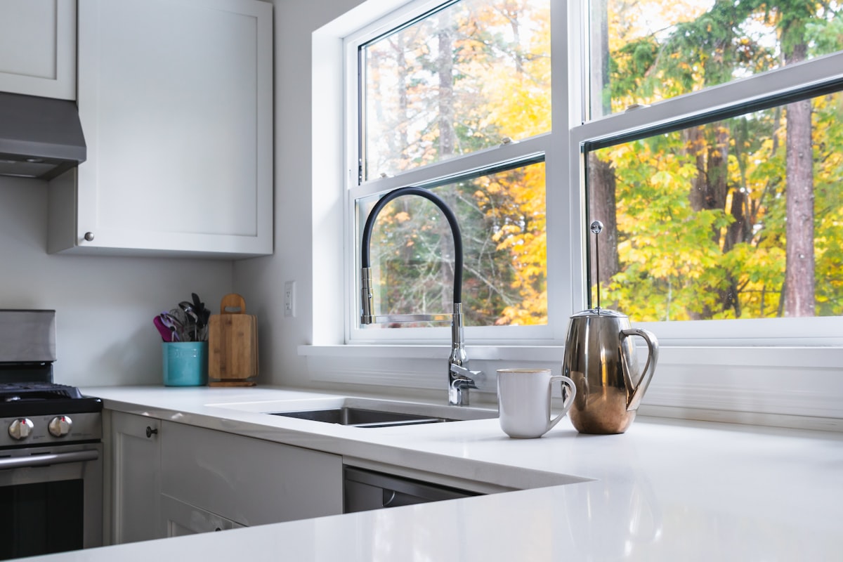 clean white kitchen with coffee cup and frenchpress on counter related to Valances for Kitchen Windows: Styles & Inspiration