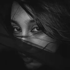 Close-up black and white of a woman's eyes. related to The Mysterious Allure of the Bed of Nails: Uncovering its Secrets