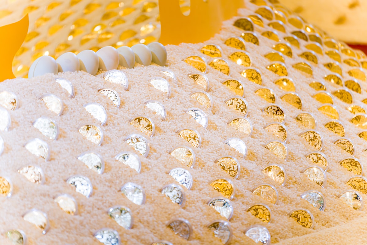 Close-up of a textured surface with gold and silver embellishments. related to Experience the Unbeatable Luxury of Gold Bed Comforters
