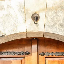 Close-up of an old wooden door with ornate hinges. related to Elegant Entryways: Chandelier Options for a Warm Welcome