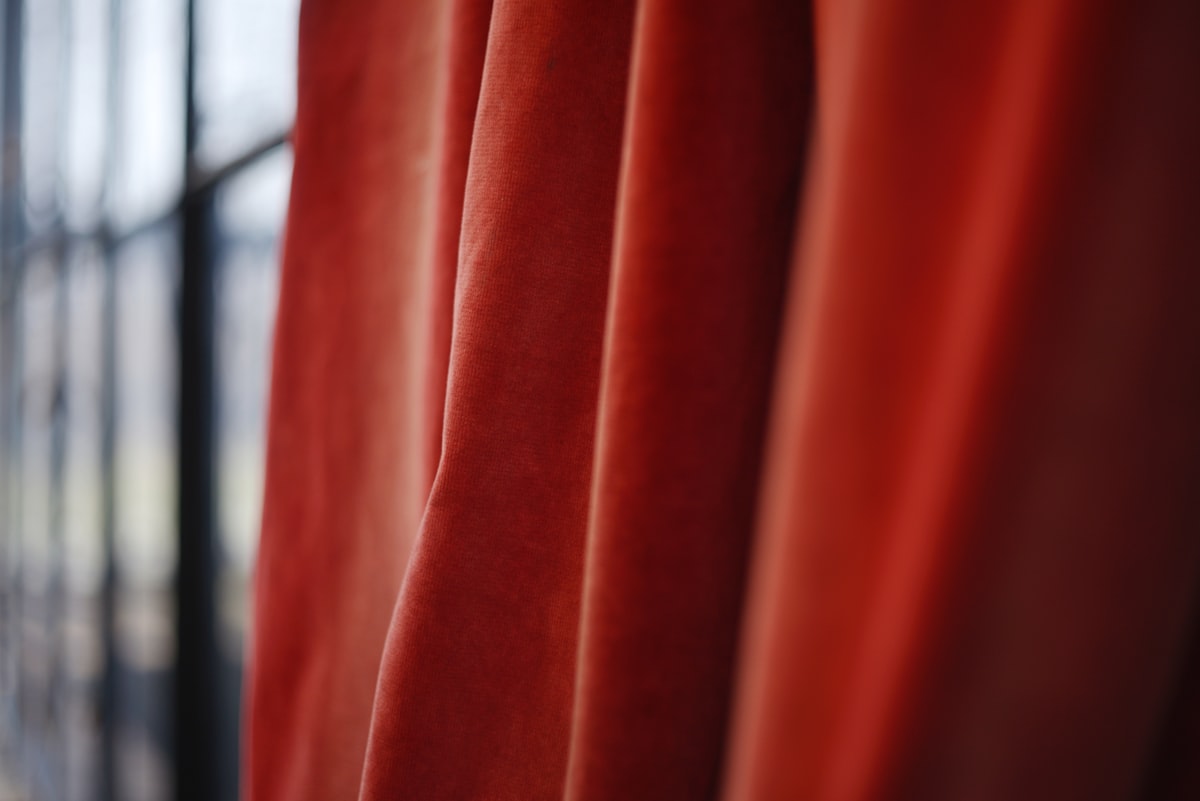 Close-up of flowing red velvet curtains related to Styling Ideas for Red Curtains with Valance