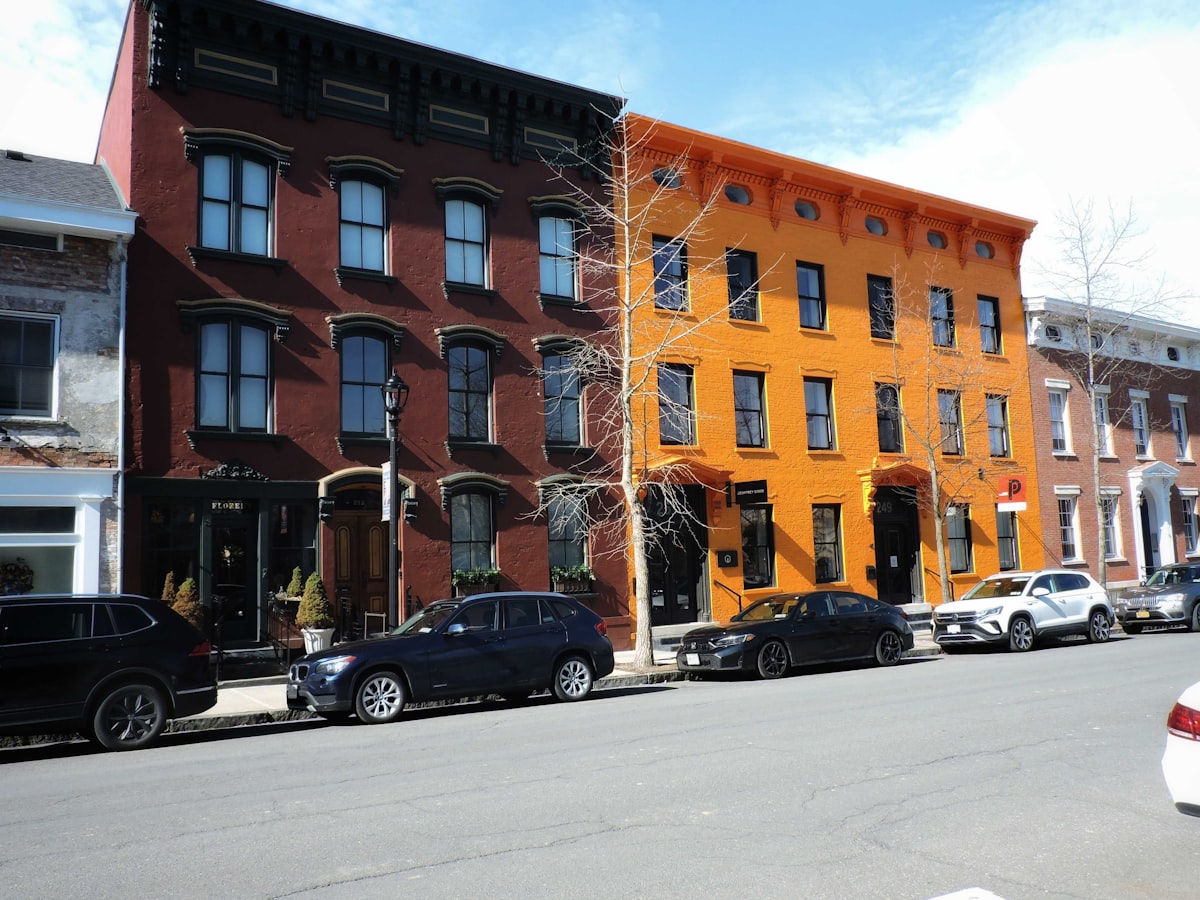 Colorful row houses stand on a city street related to Charming Bed and Breakfasts in Hudson, NY: A Cozy Getaway