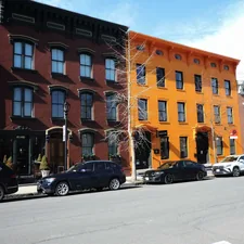Colorful row houses stand on a city street related to Charming Bed and Breakfasts in Hudson, NY: A Cozy Getaway