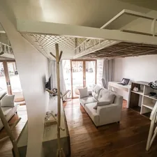 Cozy living room with white sofas and loft bed. related to Elevate Your Productivity: The Ultimate Guide to Loft Beds with Desk