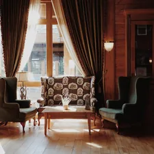 Cozy seating area with vintage chairs and patterned sofa. related to Elegant Living Room Drapes and Valances for a Stylish Space