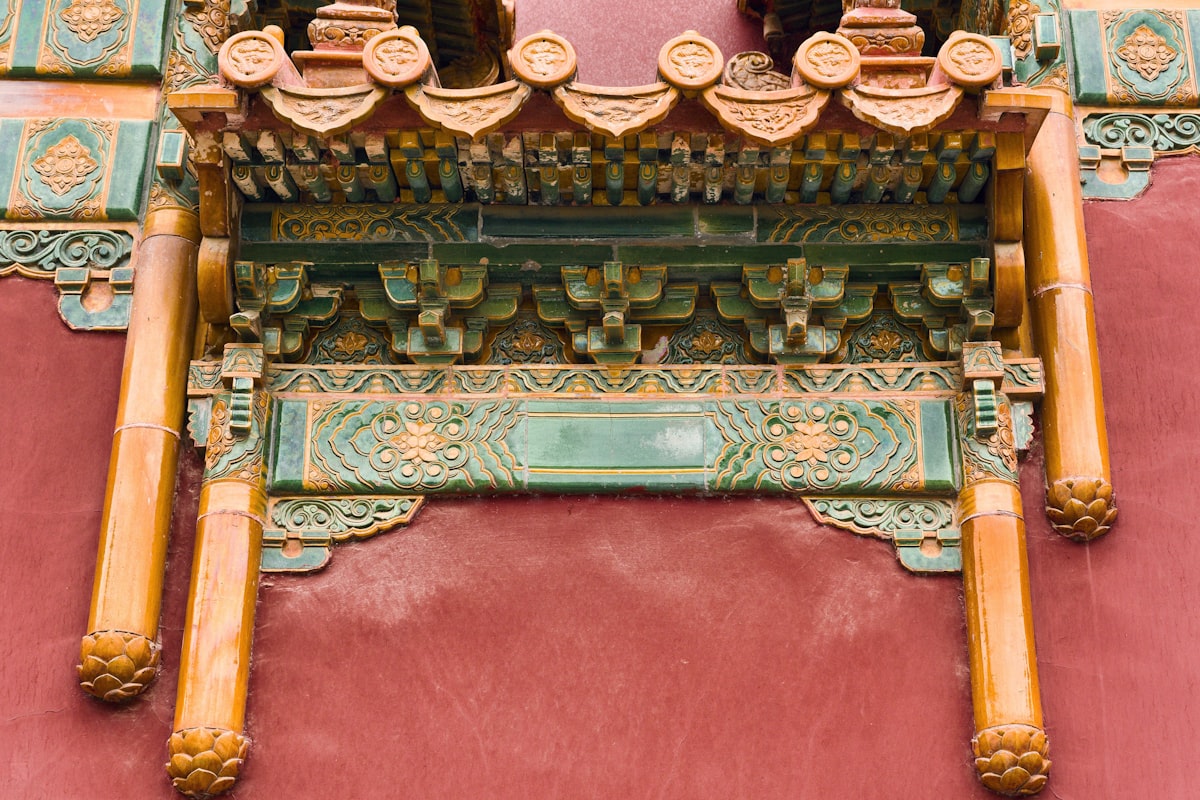 Craftsmanship on a traditional building in a historic location with detailed carvings and rich colors outside in the daytime - Visitors can see intricate wooden designs and colorful decorations on a building in a historic area during daylight. The structure shows fine craftsmanship. related to Traditional Elements of a Chinese Wedding Bed